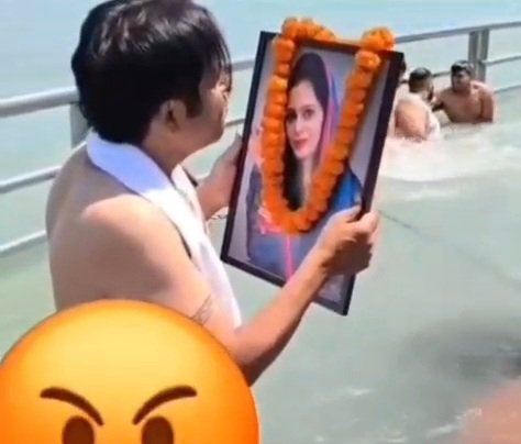 वायरल वीडियो: शख्स की अजीबोगरीब हरकत, पत्नी के फोटो पर थूका और गंगा में बहा दी!